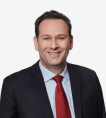 a man in a suit and red tie